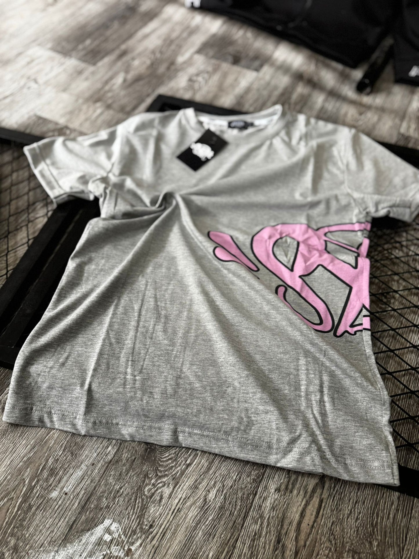 Conjunto corto syna gris logo rosa contorno negro