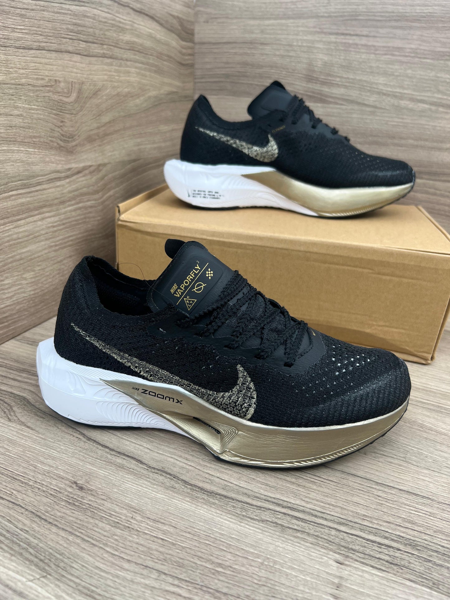 Nike ZOOMX VAPORFLY negras logo dorado detalles blanco