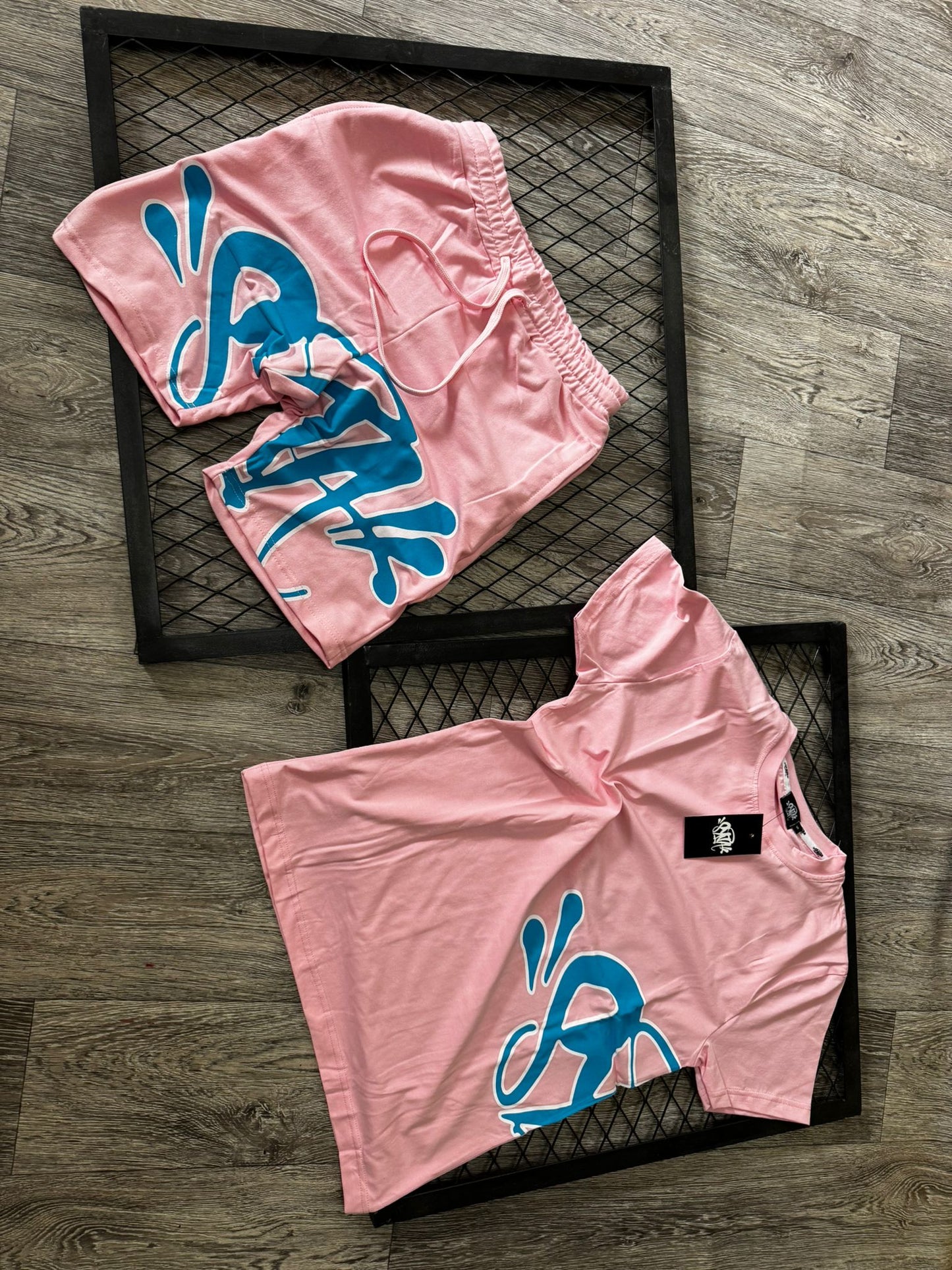 Conjunto corto syna rosa logo azul contorno blanco