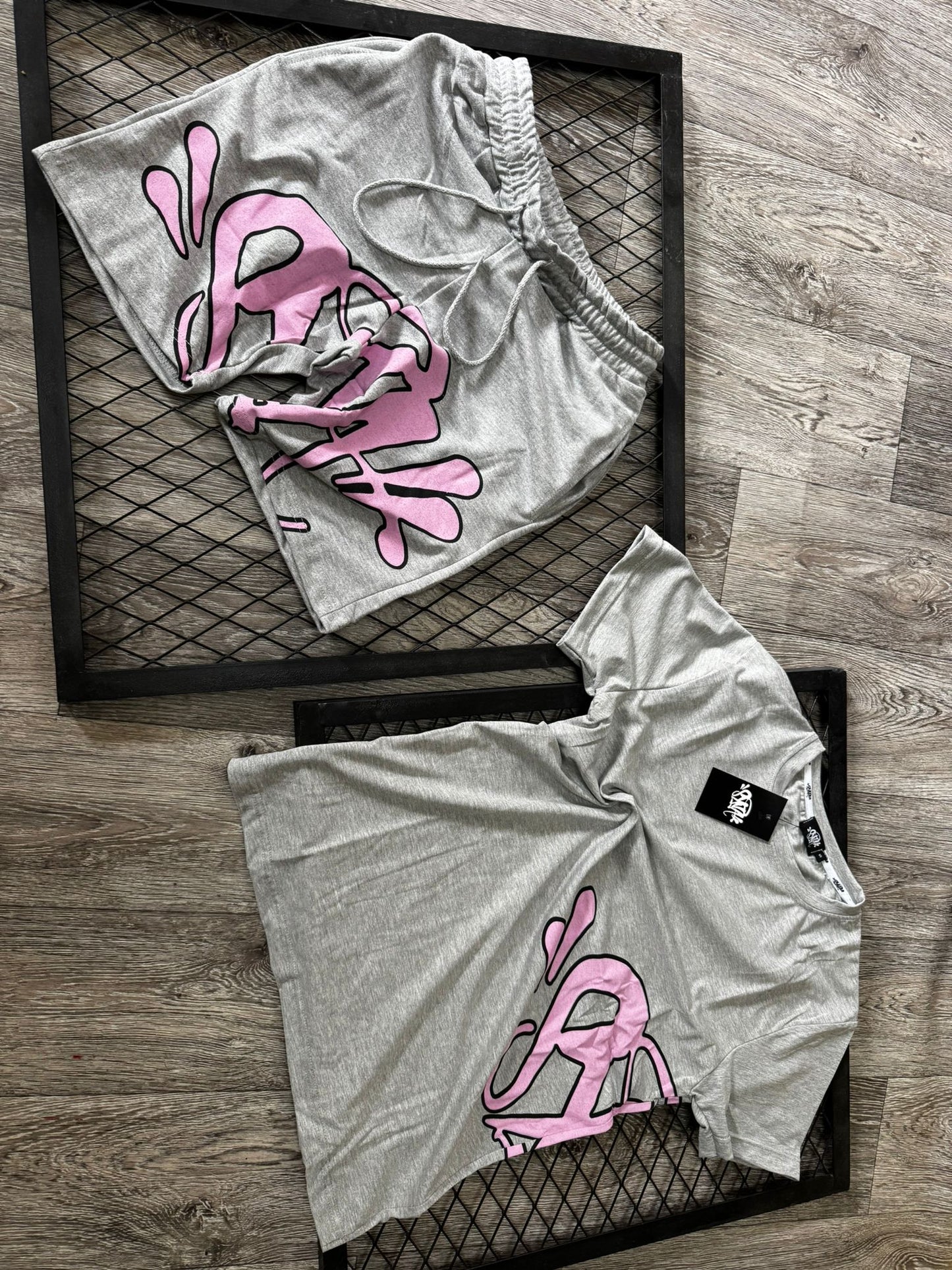 Conjunto corto syna gris logo rosa contorno negro