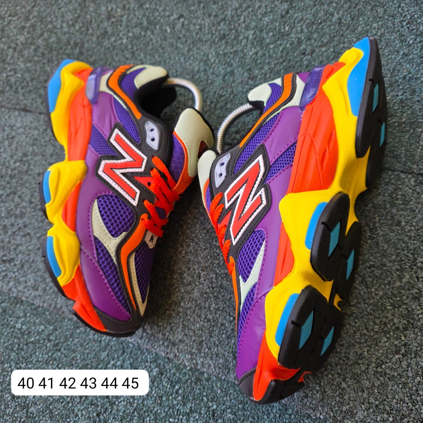 NEW BALANCE 9060 moradas logo naranja detalles amarillos y azules