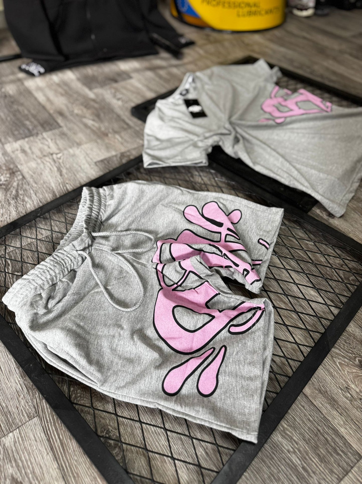 Conjunto corto syna gris logo rosa contorno negro