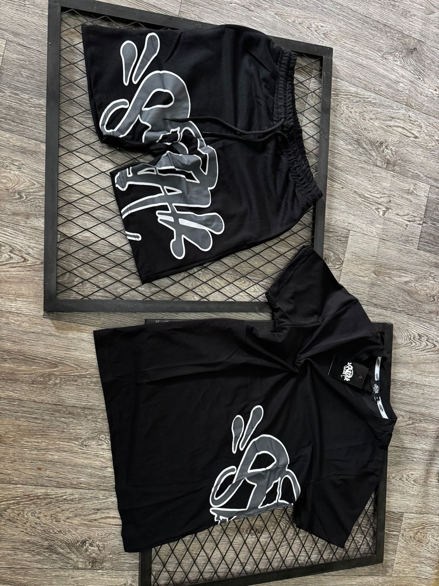 Conjunto corto syna negro logo gris contorno blanco
