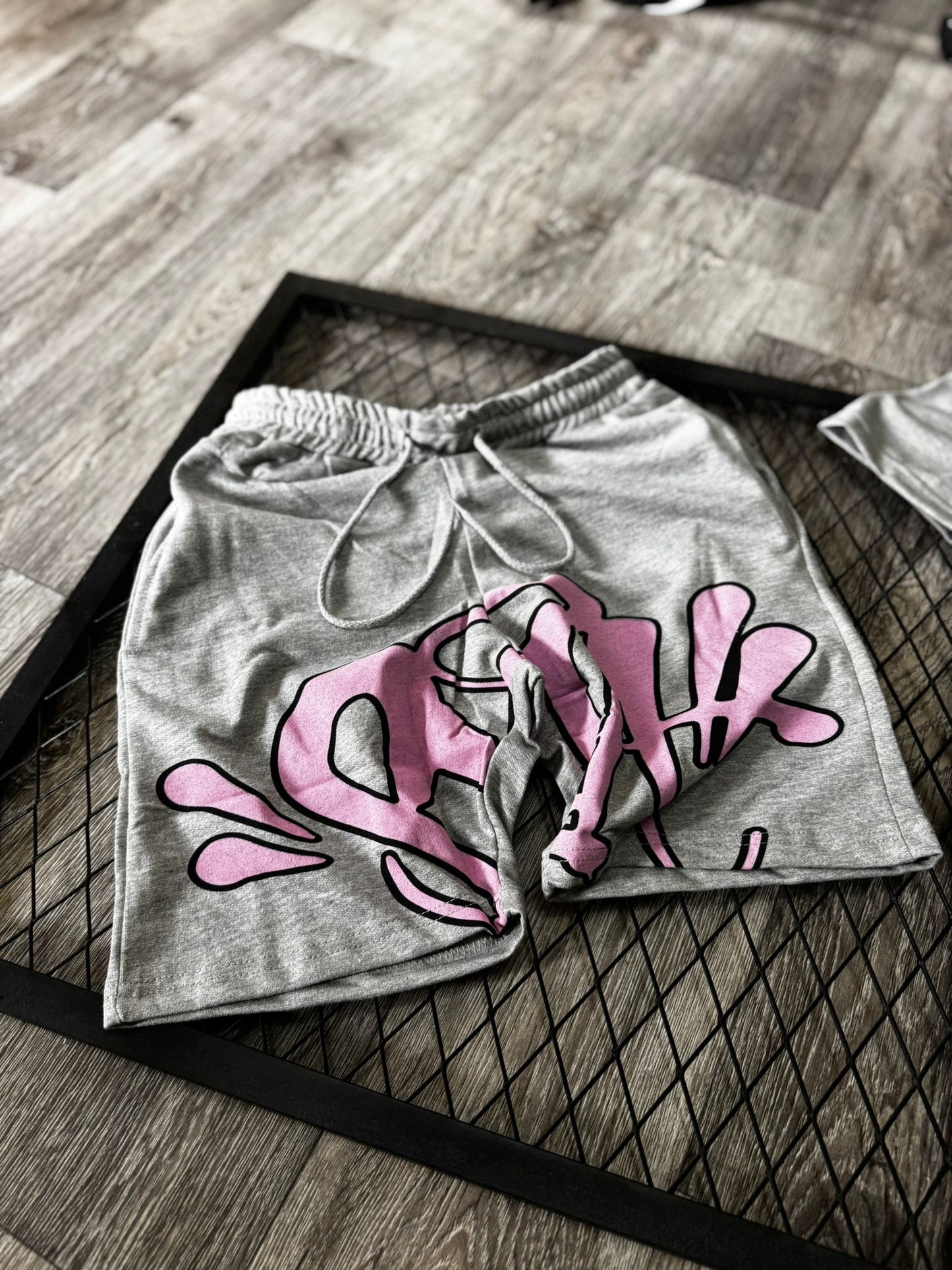 Conjunto corto syna gris logo rosa contorno negro
