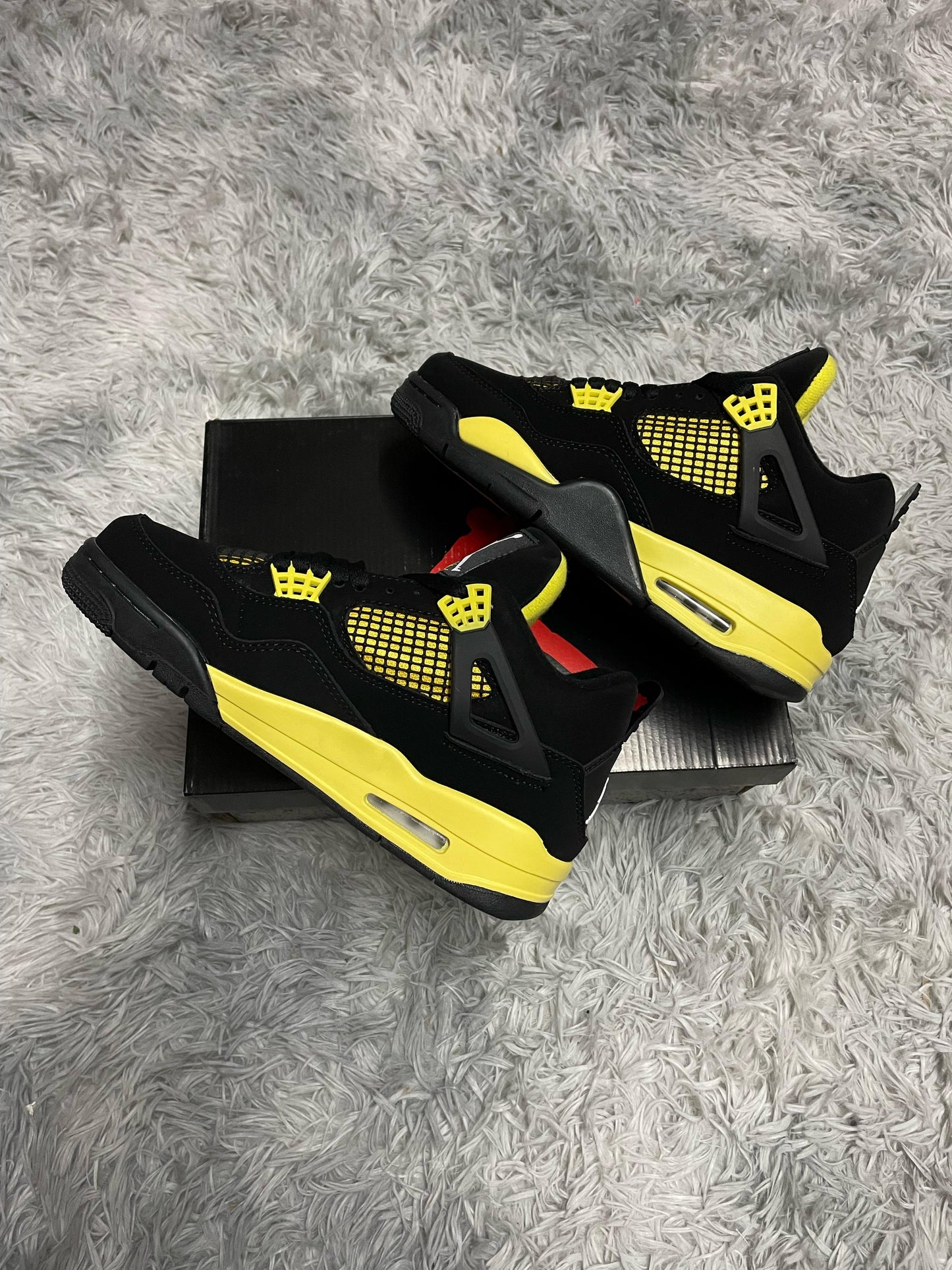 JORDAN 4 NEGRAS DETALLES AMARILLOS LOGO BLANCO