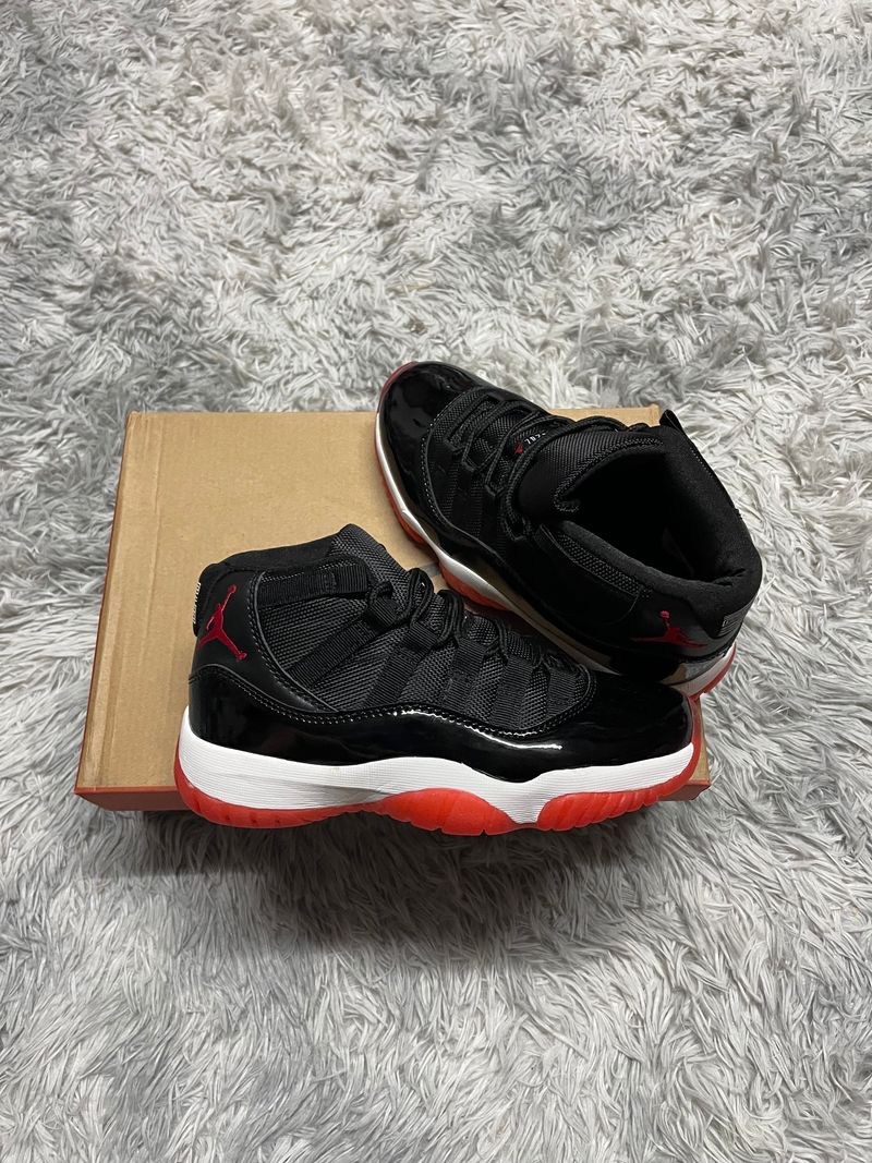 JORDAN 11 negro logo rojo detalles blancos