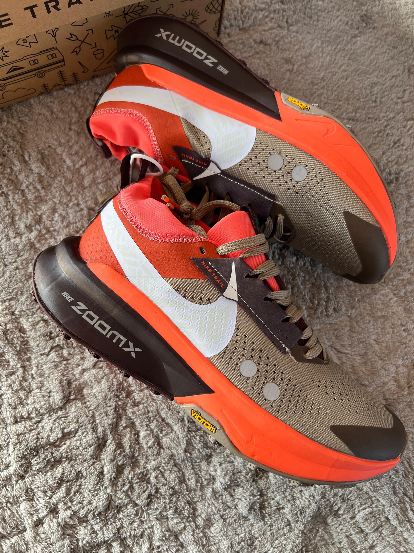 Nike ZOOMX ZEGAMA TRAIL 2 naranjas y marron logo blanco