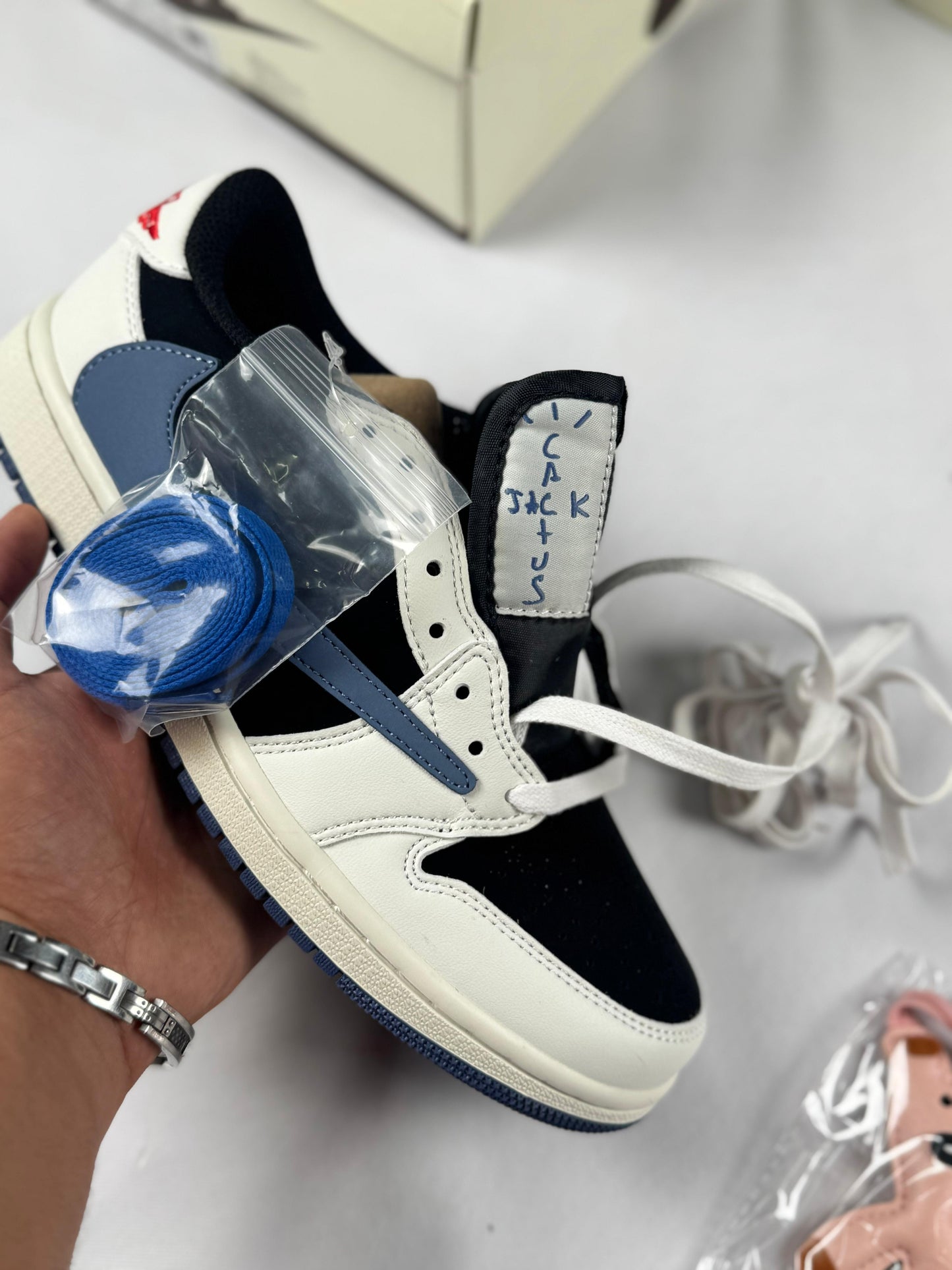 Air Jordan Low x Travis Scott blancas y negras logo azul