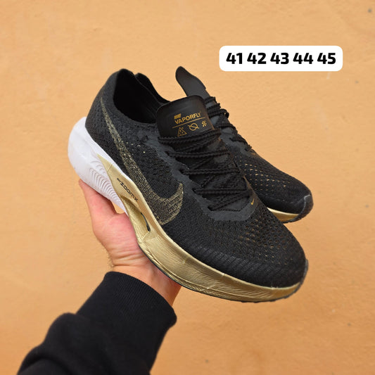 Nike ZOOMX VAPORFLY negras logo dorado detalles blancos