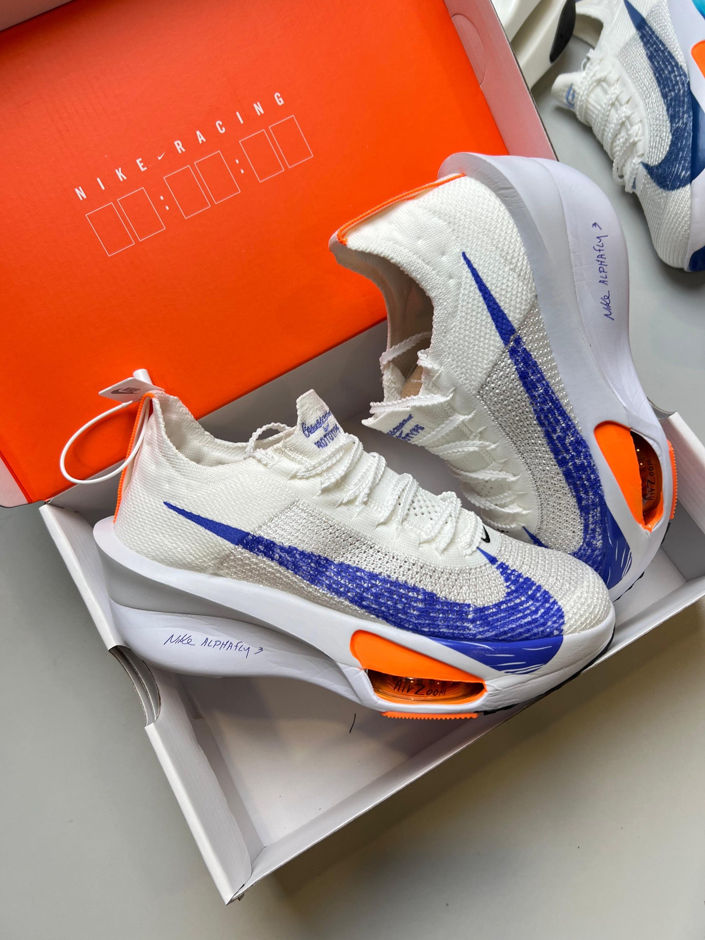 NIKE AIR ZOOM ALPHAFLY NEXT % blanco logo azul detalles naranja