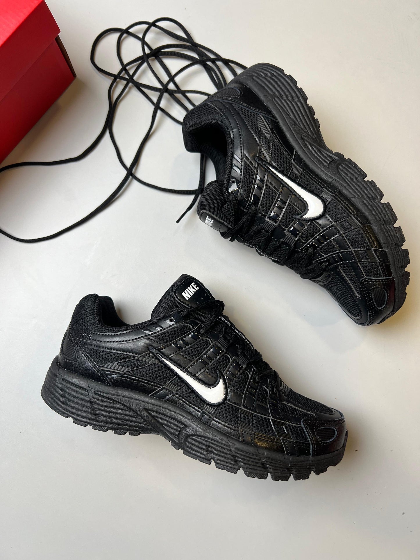 Nike P-6000 negras logo banco