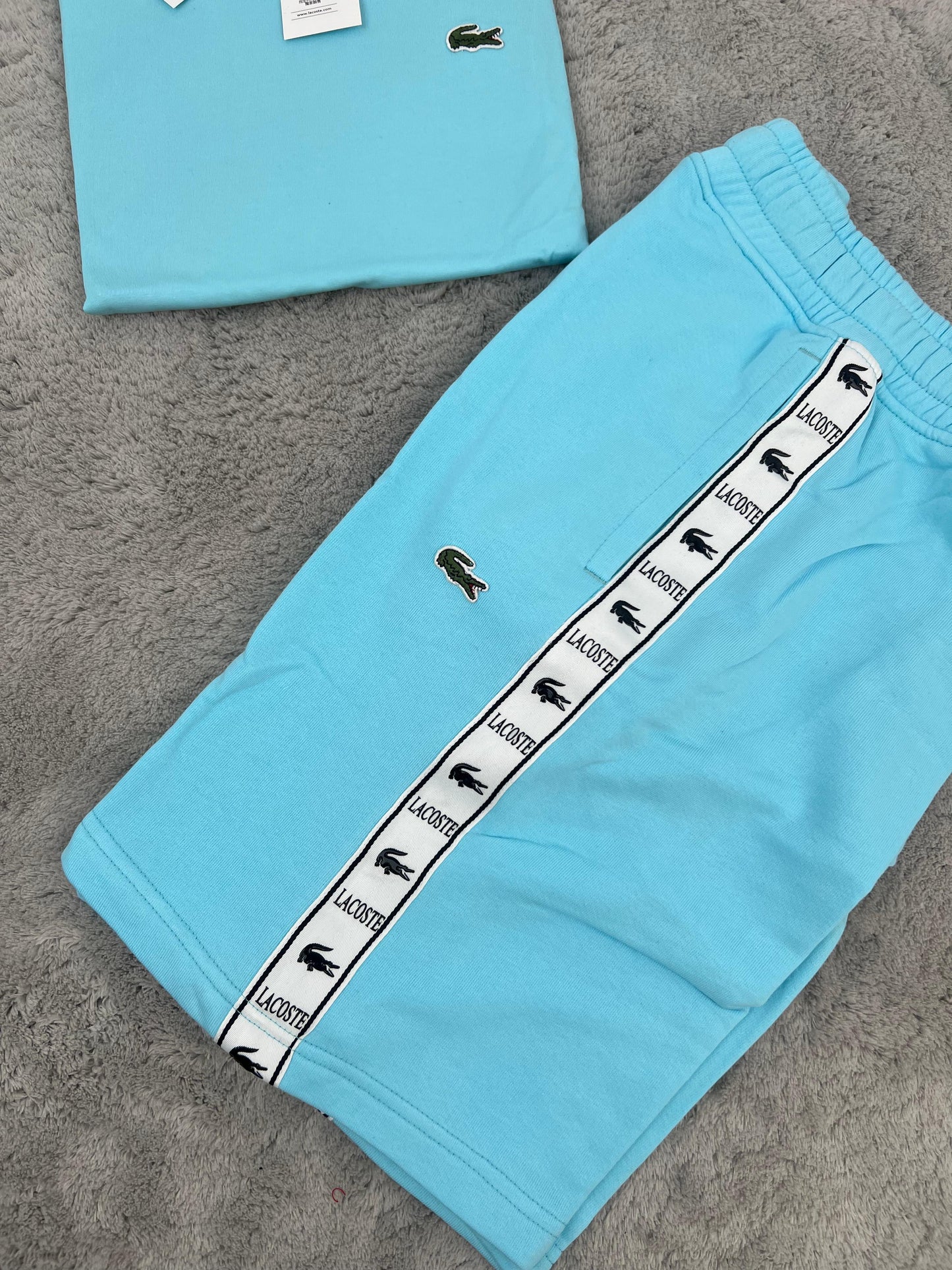 Conjunto corto lacoste azul claro logo verde lineas blancas