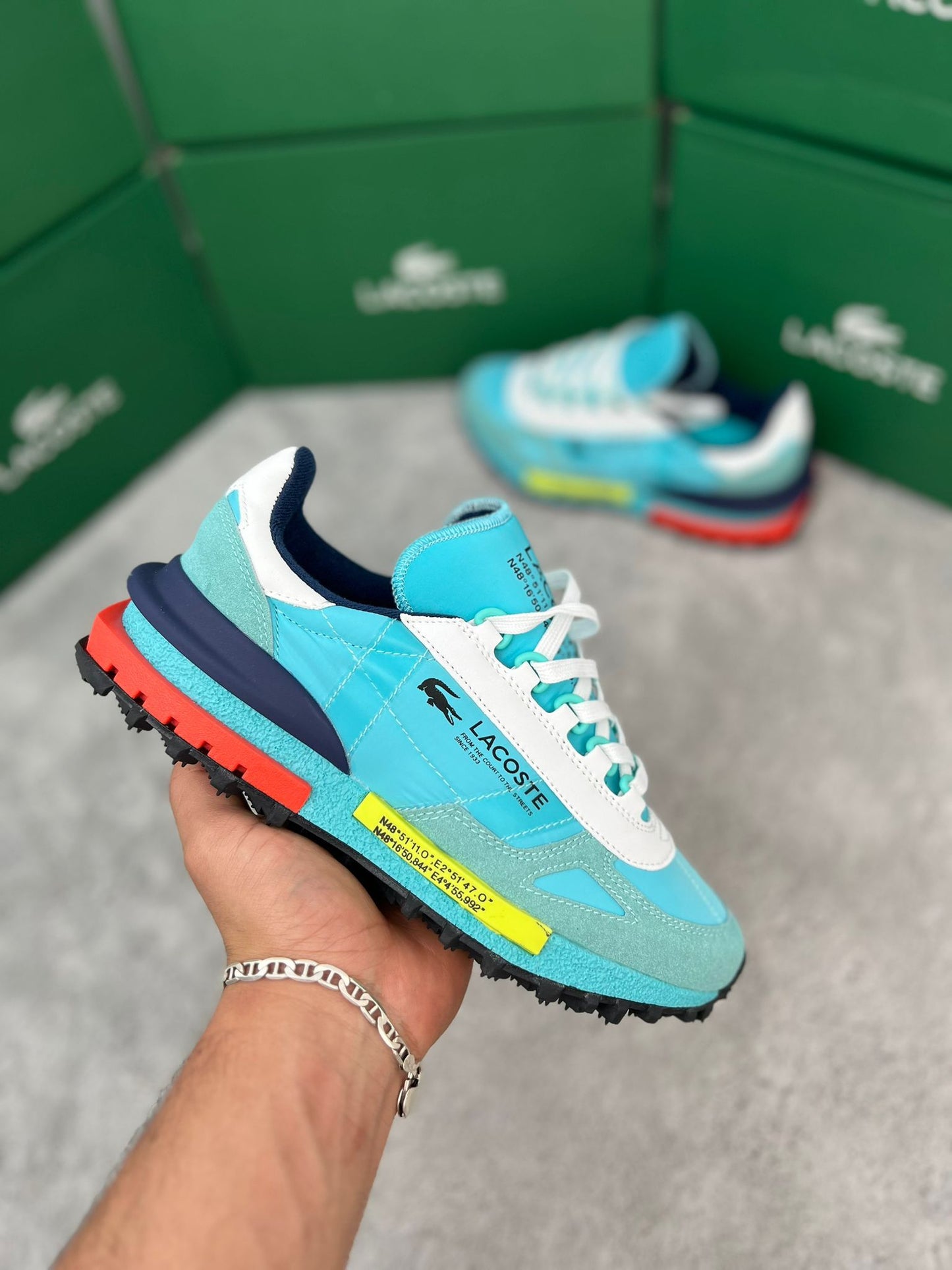 Zapatillas Lacoste Elite Active azul claro logo negro detalles amarillos y naranjas