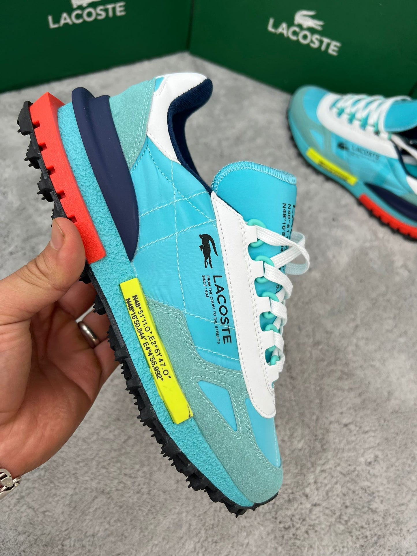 Zapatillas Lacoste Elite Active azul claro logo negro detalles amarillos y naranjas