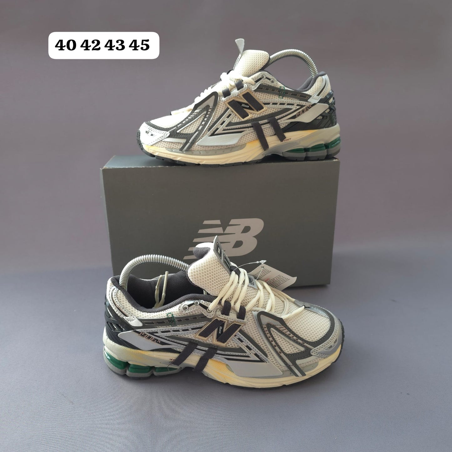 NEW BALANCE 1906R gris logo negro contorno dorado