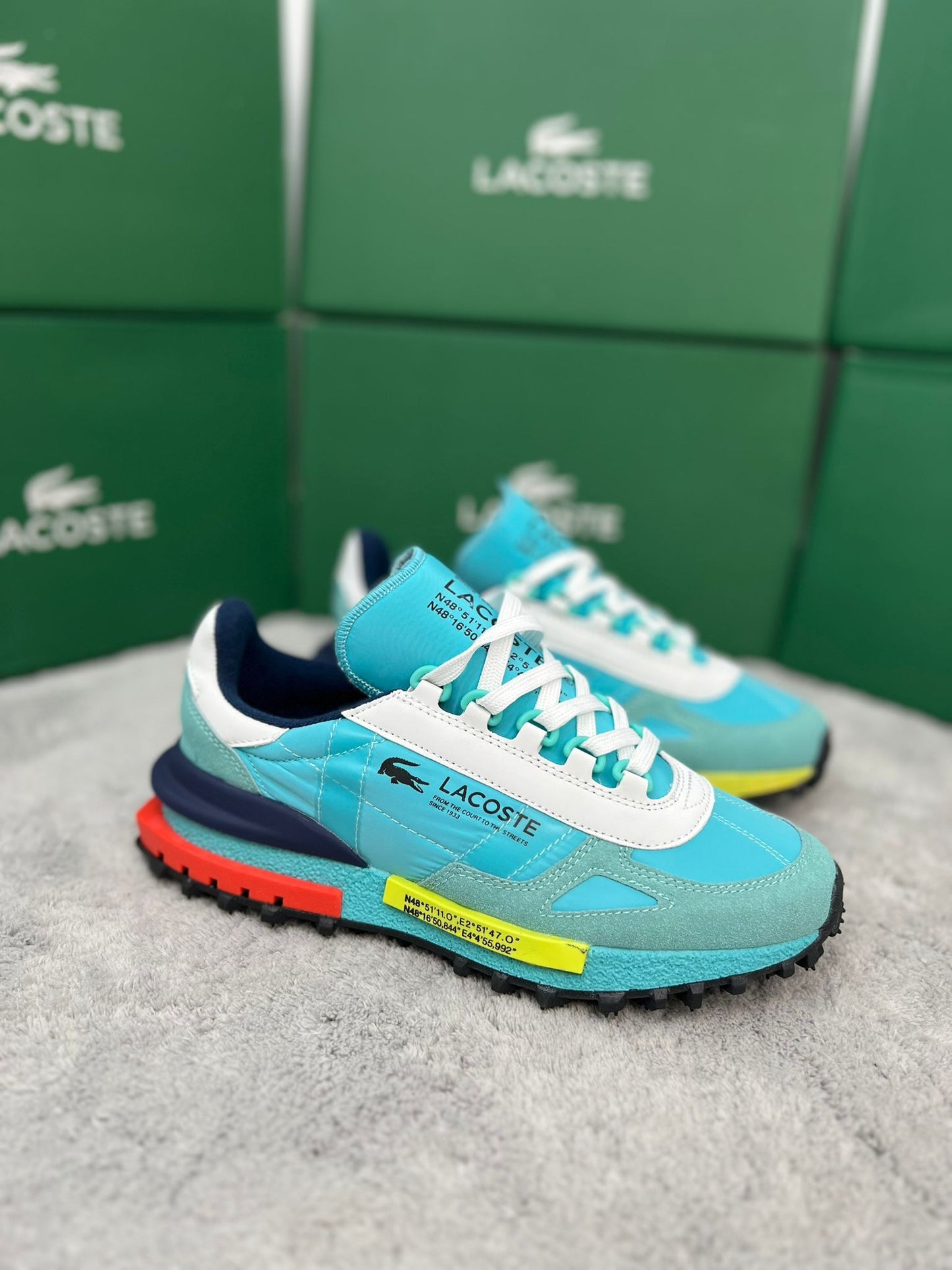 Zapatillas Lacoste Elite Active azul claro logo negro detalles amarillos y naranjas