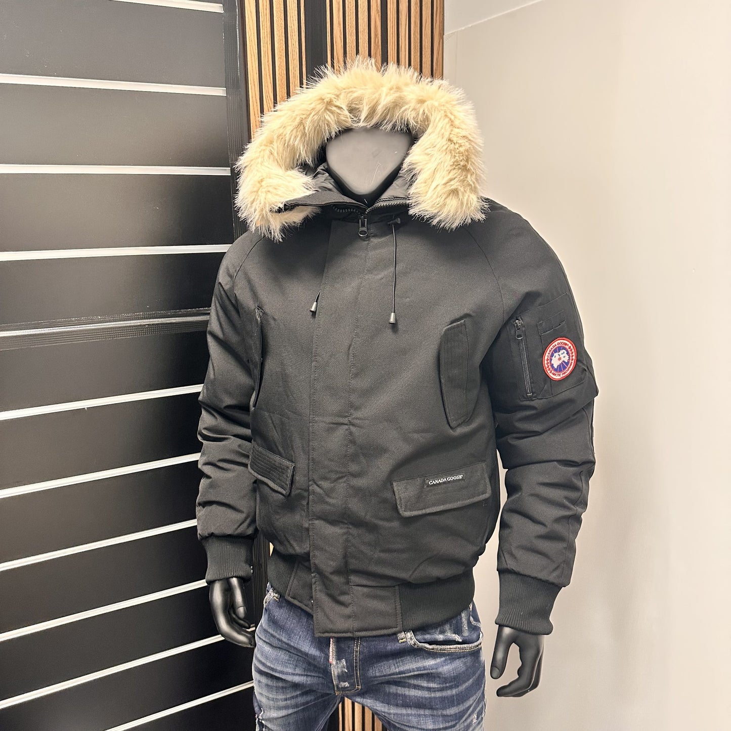 Chaqueta Canada Goose negro logo azul y rojo gorro pelos