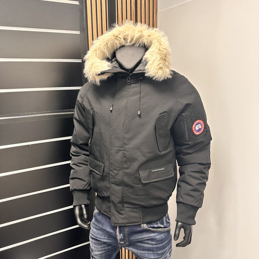 Chaqueta Canada Goose negro logo azul y rojo gorro pelos