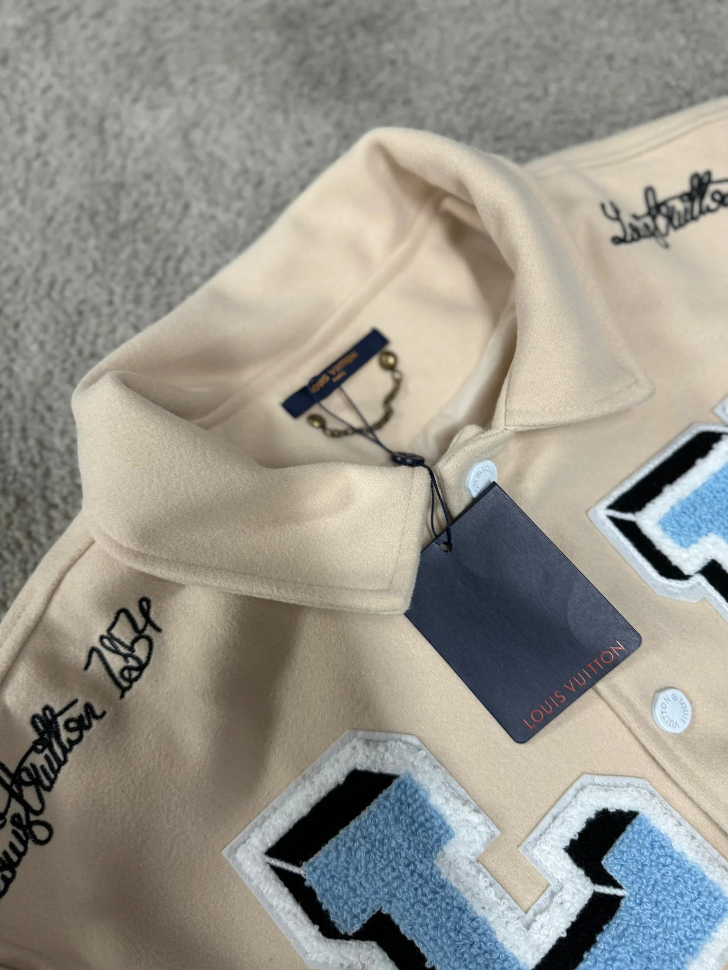 Chaqueta LV beige logo azul detalles blancos