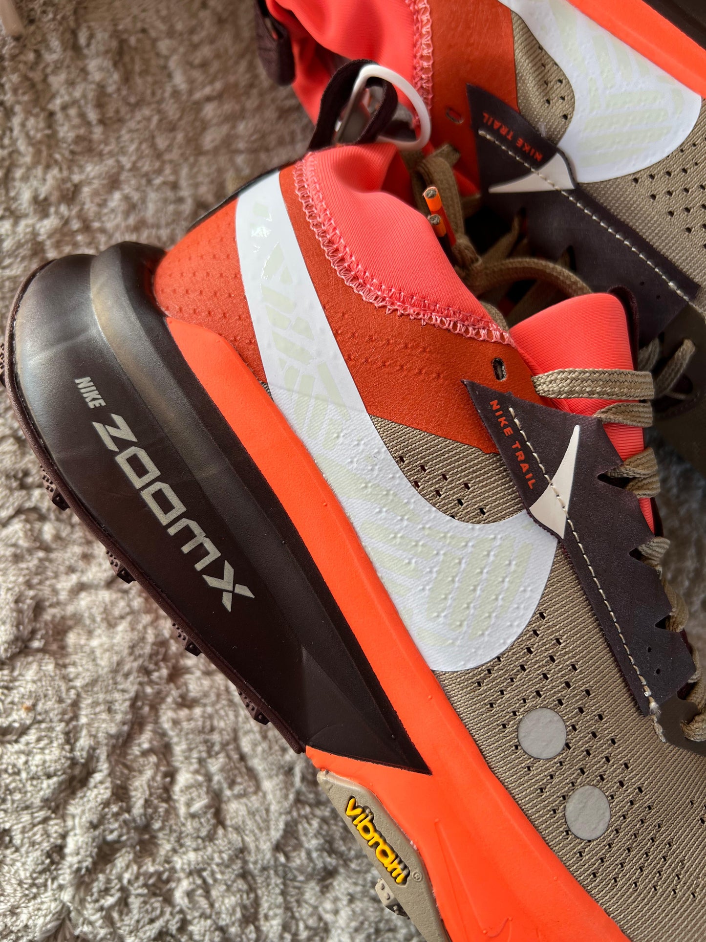 Nike ZOOMX ZEGAMA TRAIL 2 naranjas y marron logo blanco