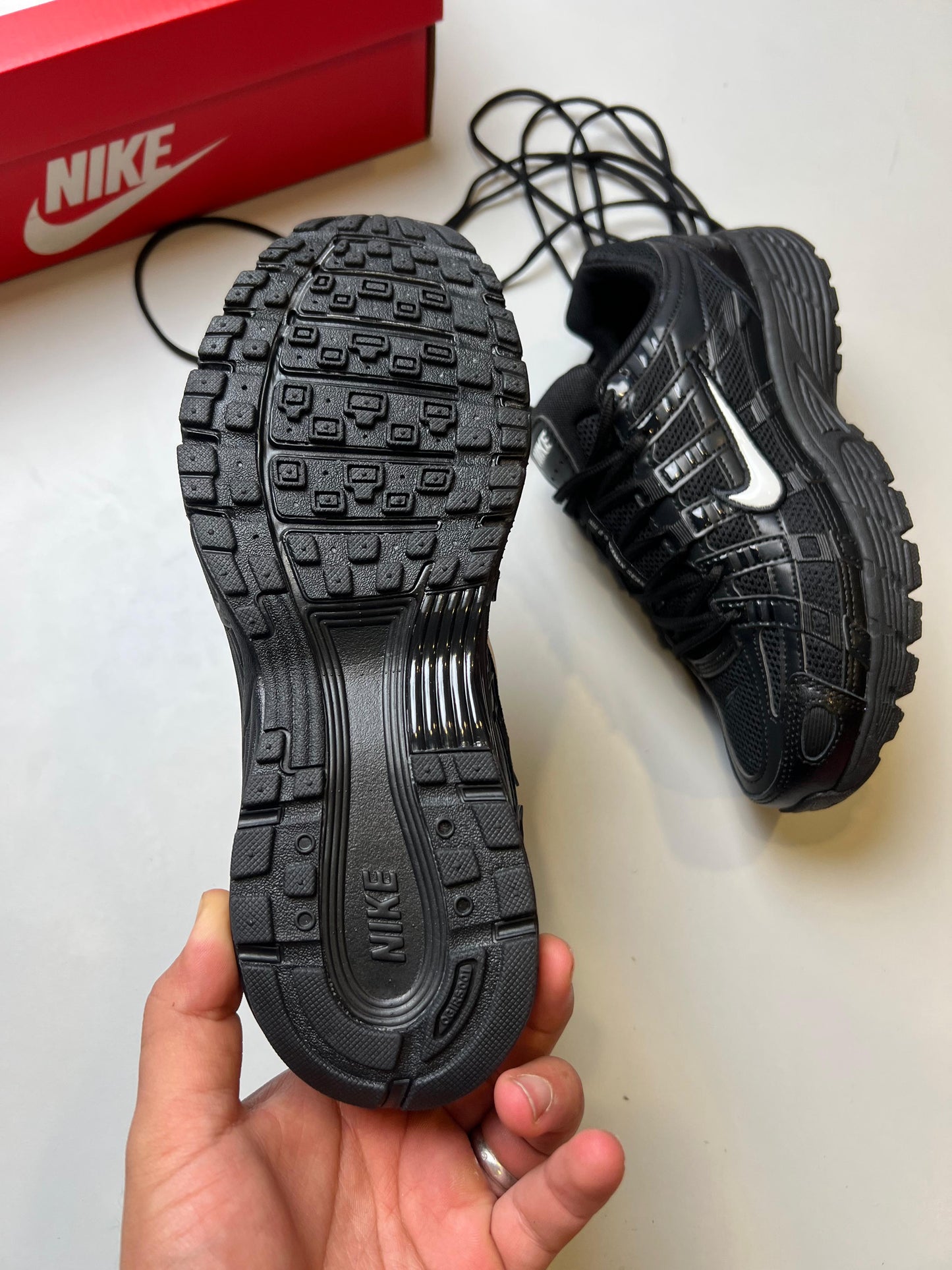 Nike P-6000 negras logo banco