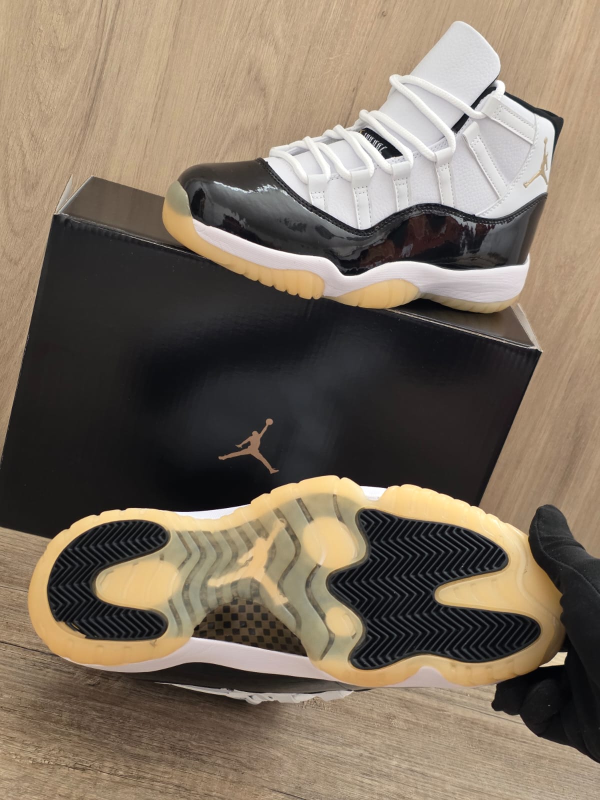 Jordan 11 negra suela blanca logo oro