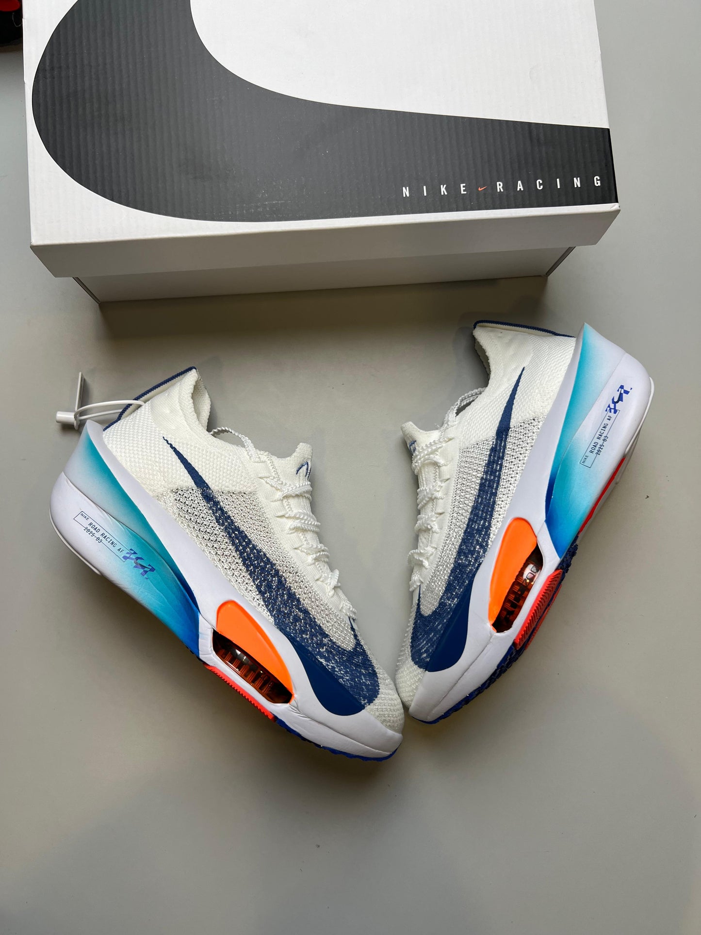 NIKE AIR ZOOM ALPHAFLY NEXT % blanco logo azul detalles naranjas