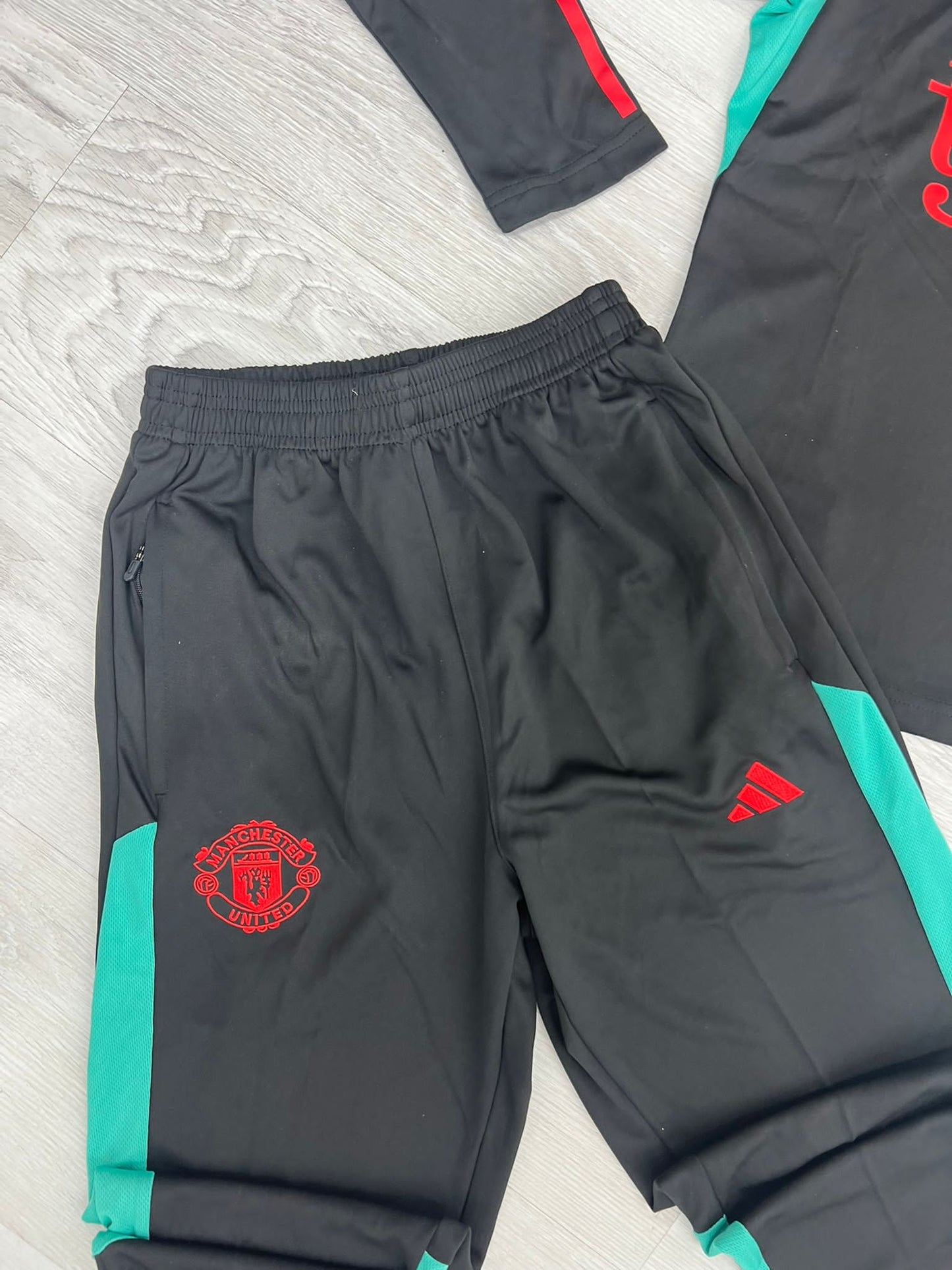 Chandal Manchester United negro detalles rojos y verde