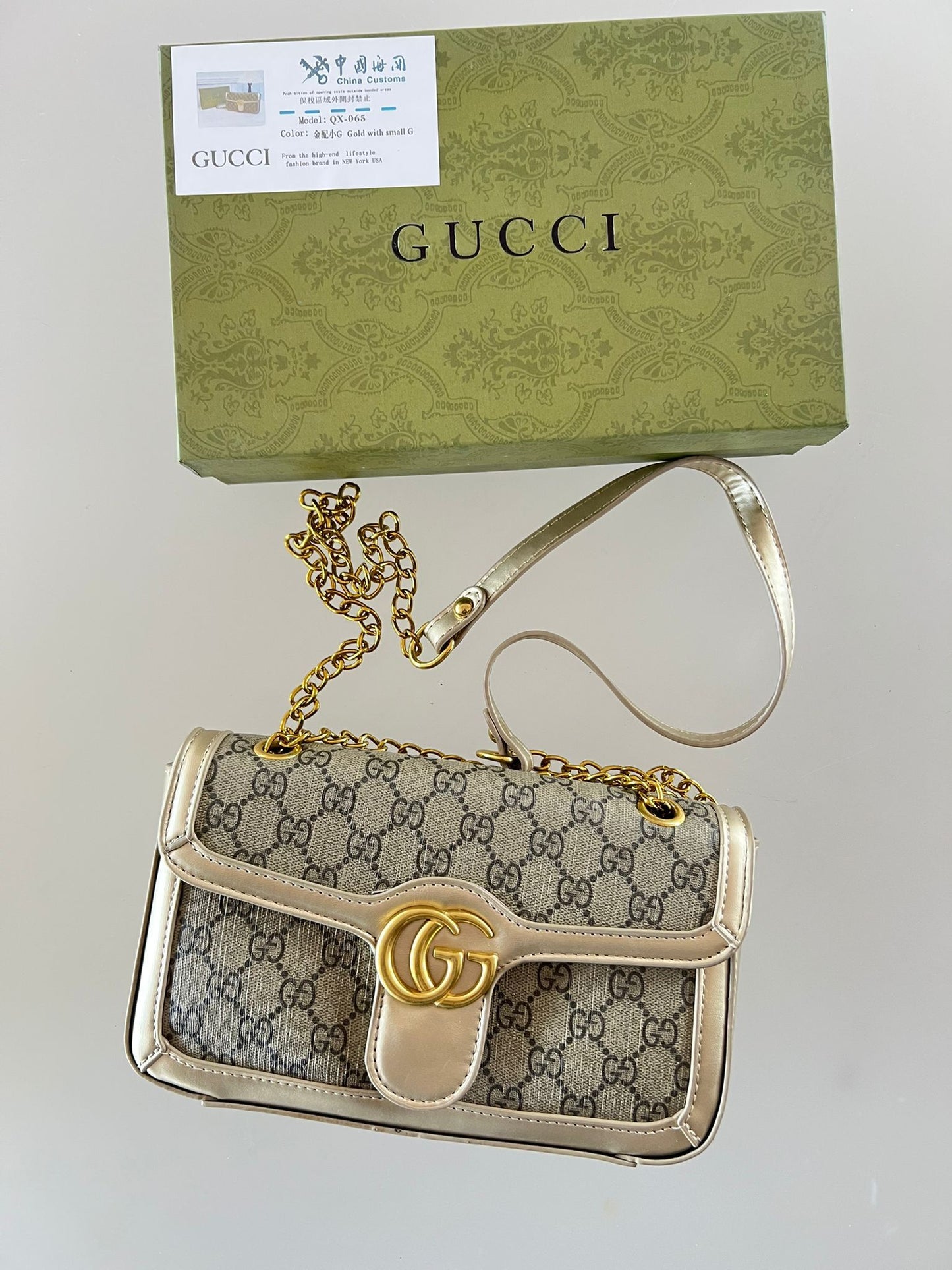 Bolso Gucci beige y negra logo dorado