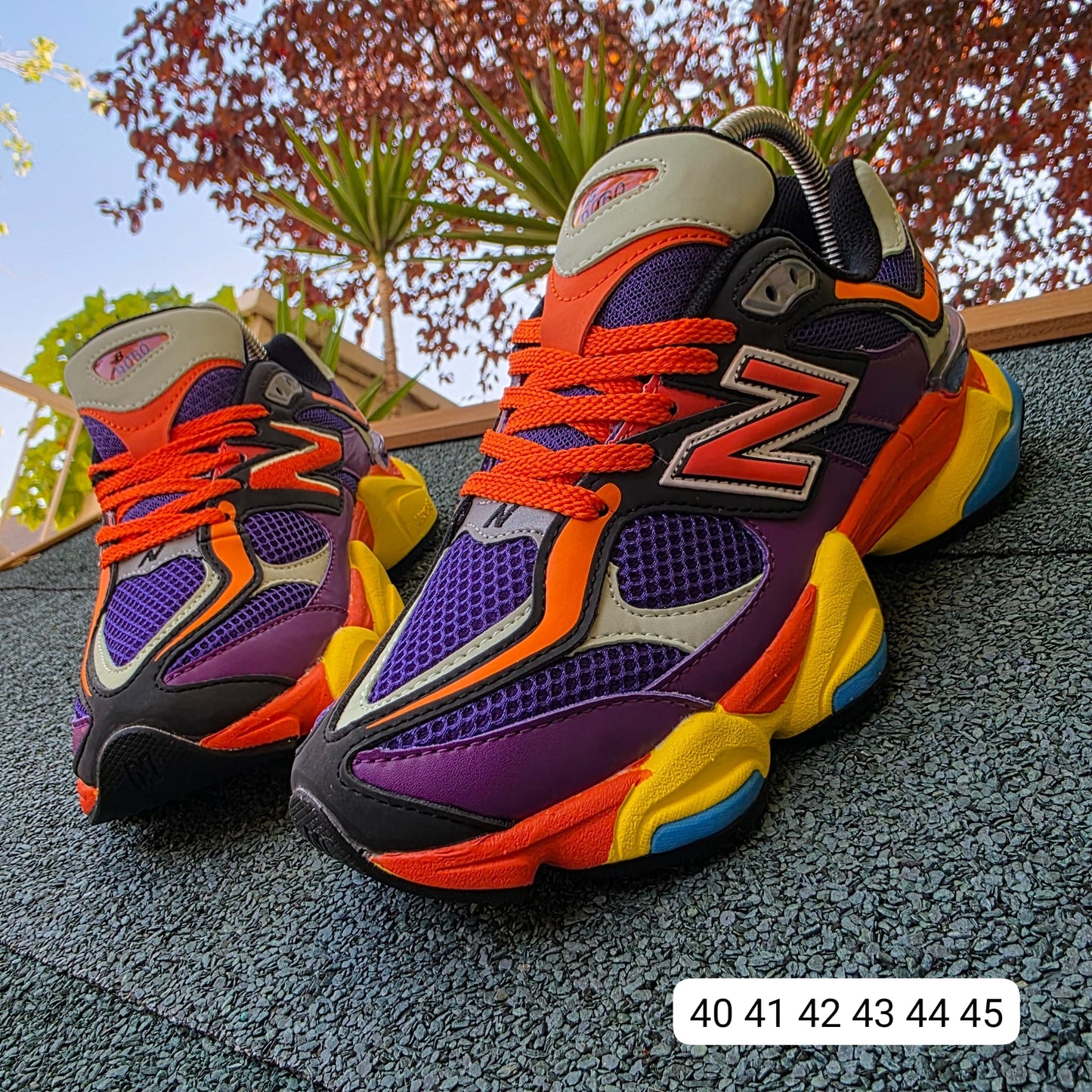 NEW BALANCE 9060 moradas logo naranja detalles amarillos y azules
